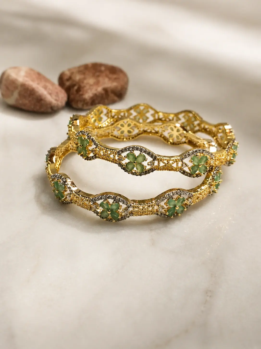 golden bangles with green stones