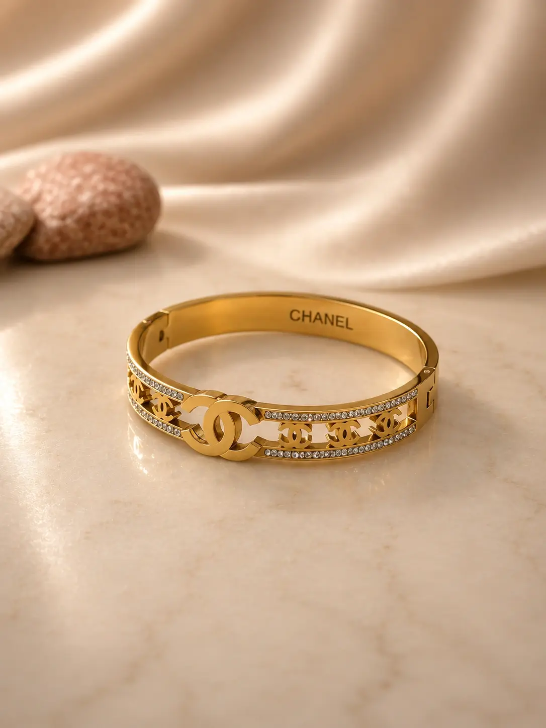gold interlocking motif bangle with two clear accent rows