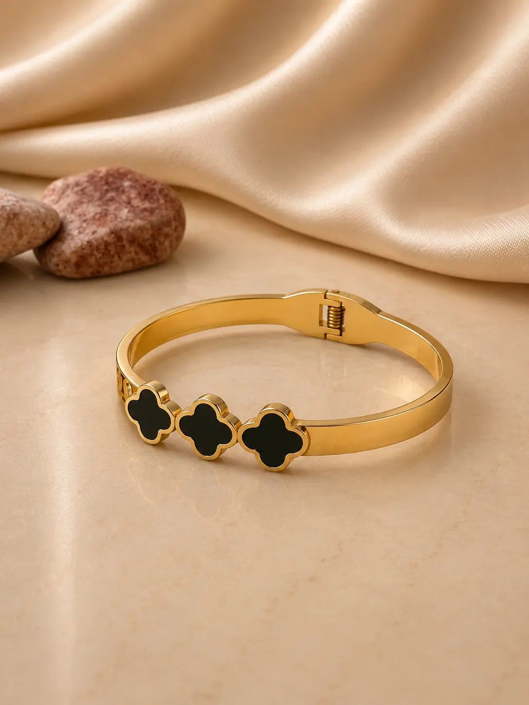 gold tone triple black clover hinged bangle with clasp closure