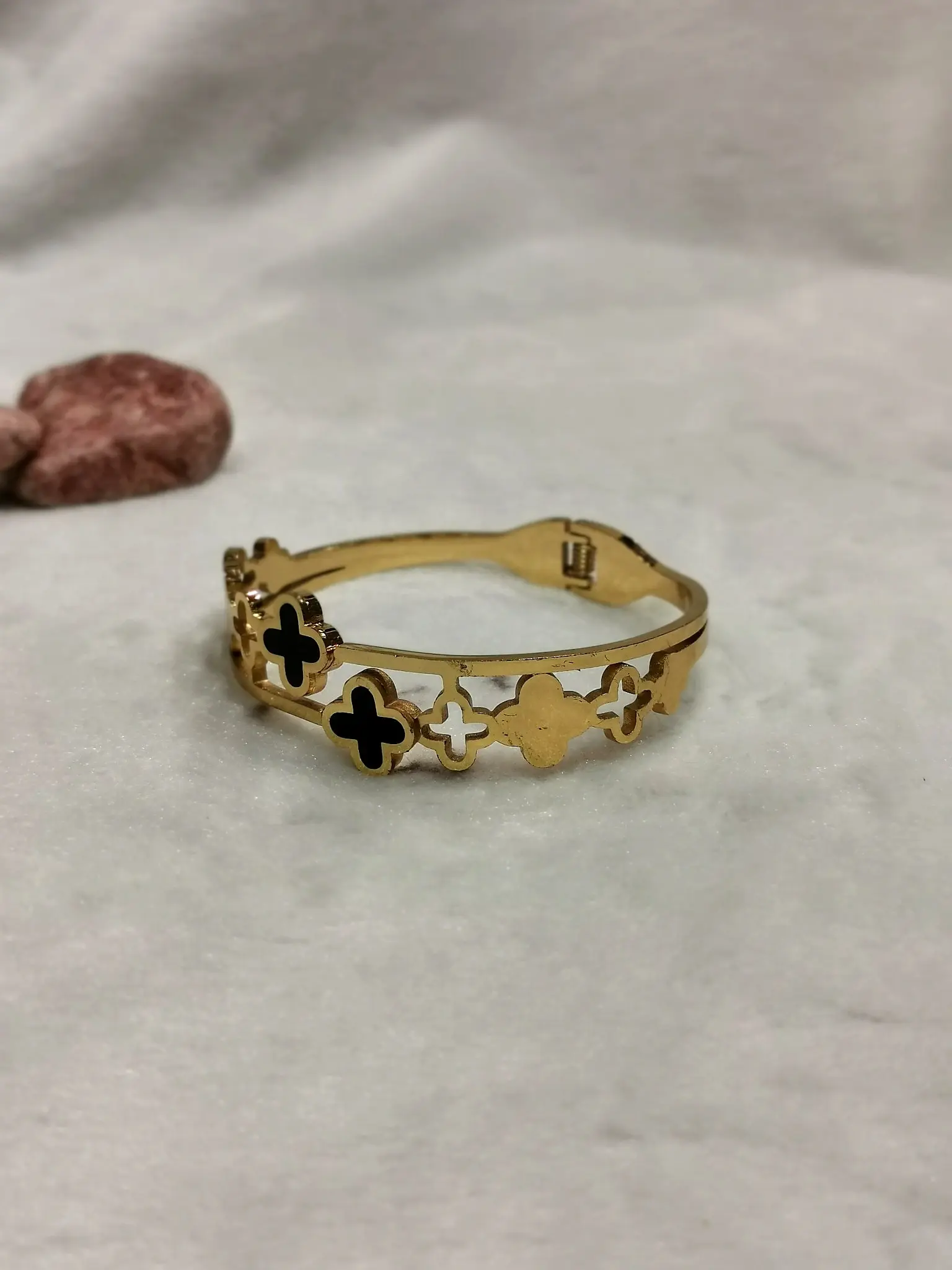 gold tone black clover hinged bangle with openwork design
