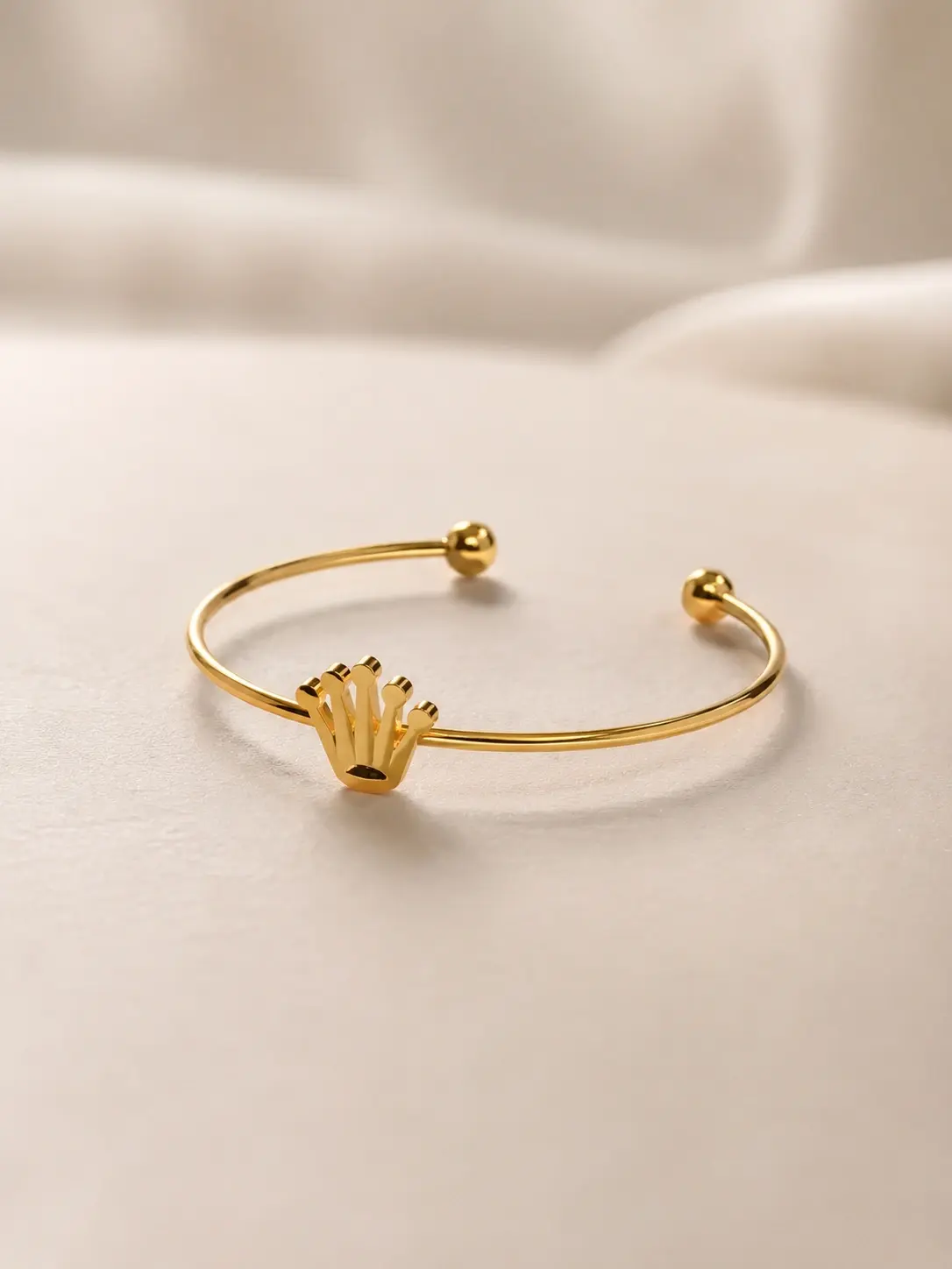 gold tone crown open cuff bracelet with polished ball ends