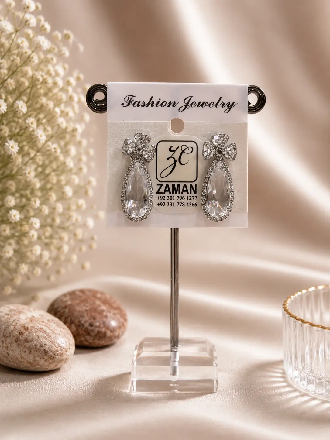 Silver Bow Teardrop Halo Earrings with clear bow tops and large pear-shaped drops