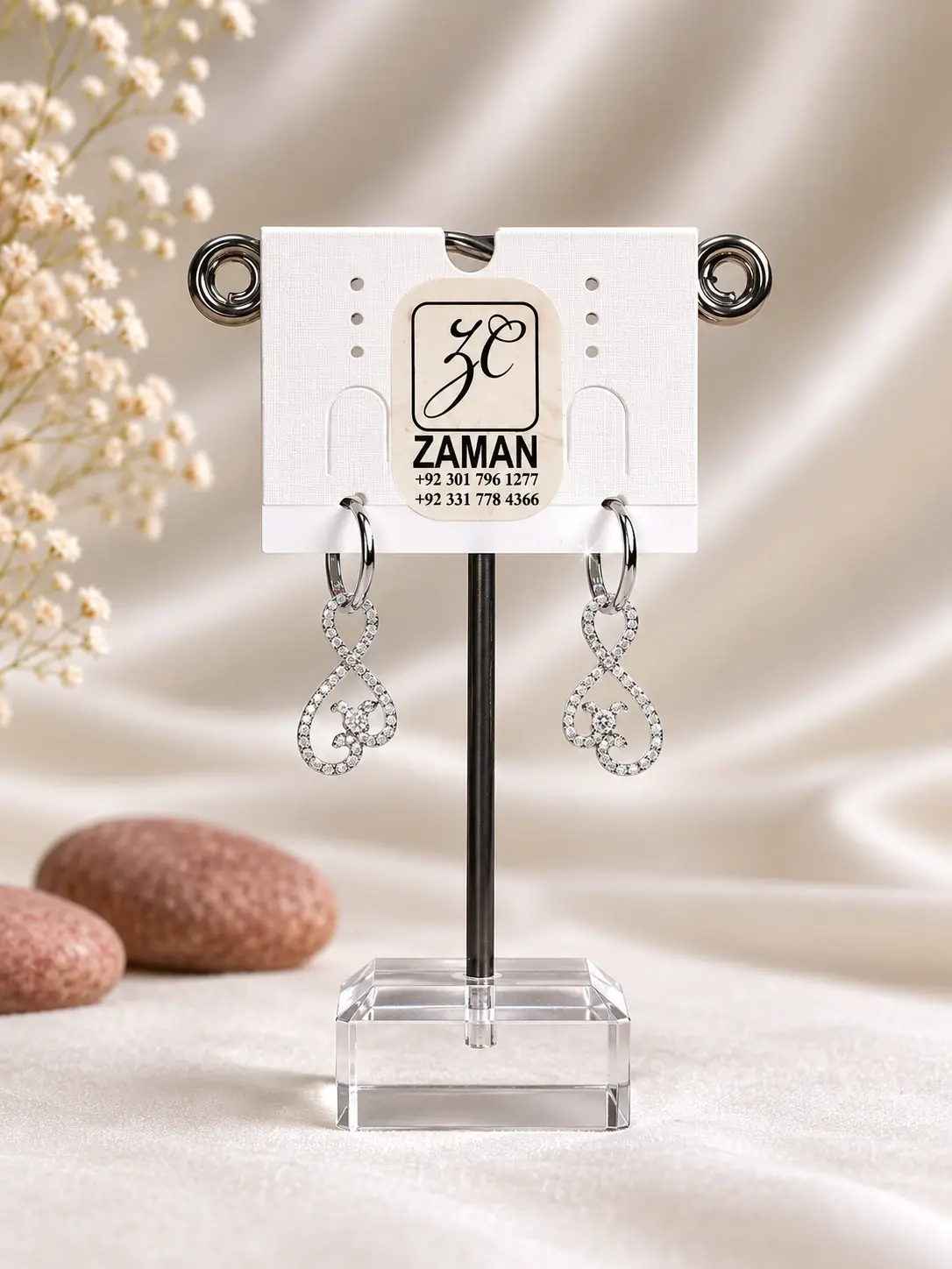Silver Infinity Swirl Drop Earrings with clear curved accents and polished hoop attachments