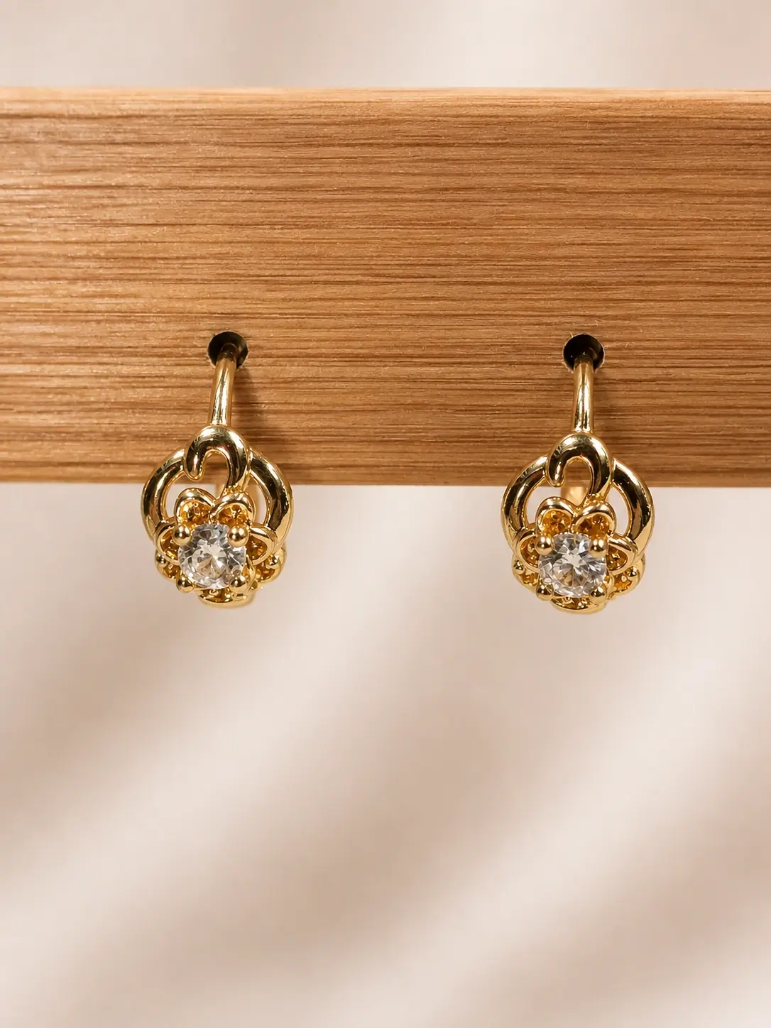 Gold Floral Loop Stone Earrings with polished curved frames and clear round central accents