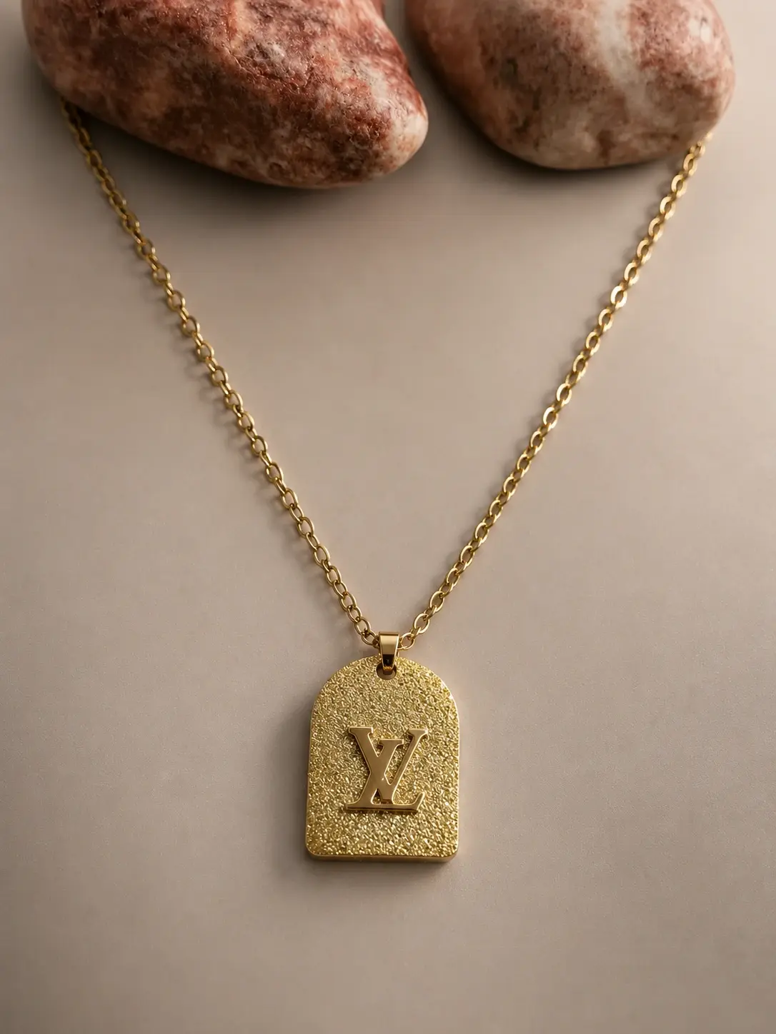 gold textured arch pendant necklace with raised polished centerpiece