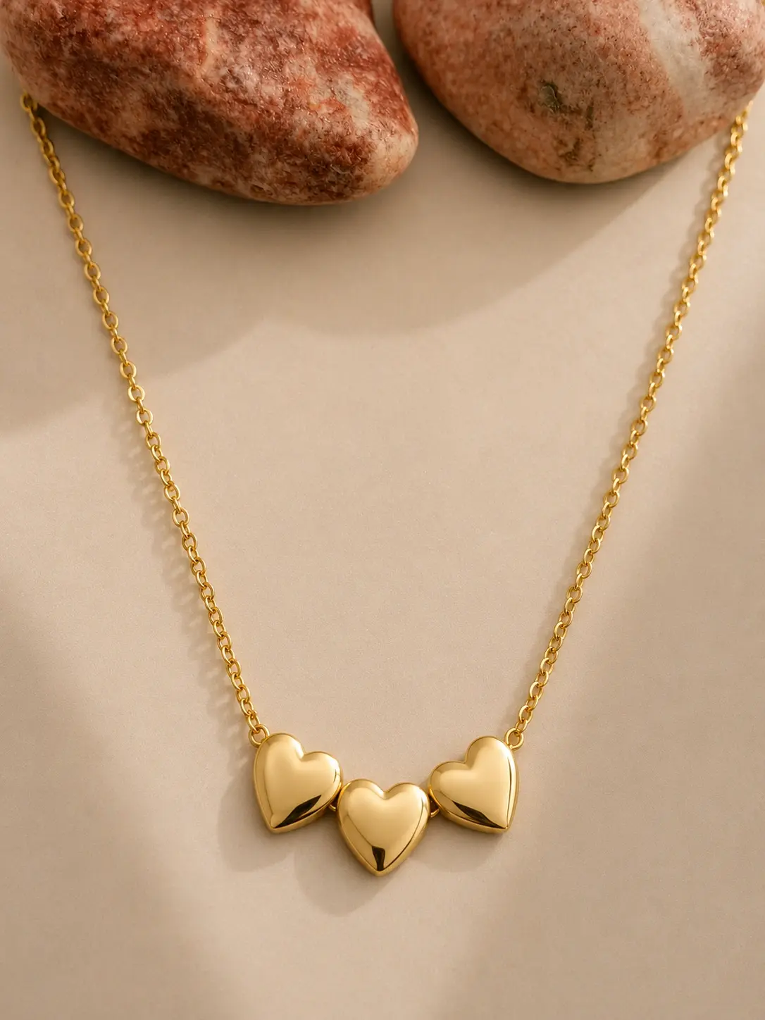 gold triple heart necklace with three polished heart motifs