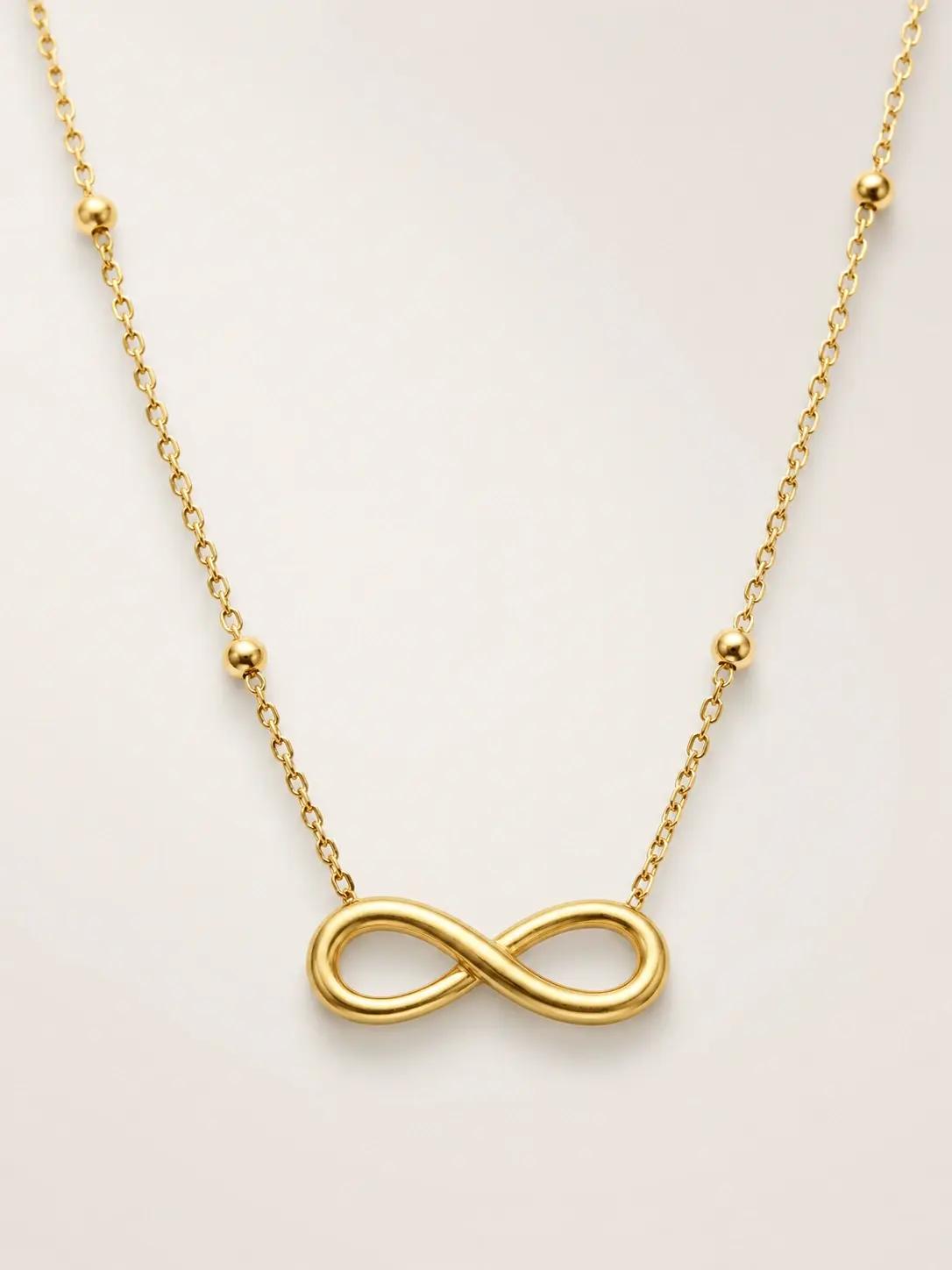 gold infinity symbol necklace with polished bead accents