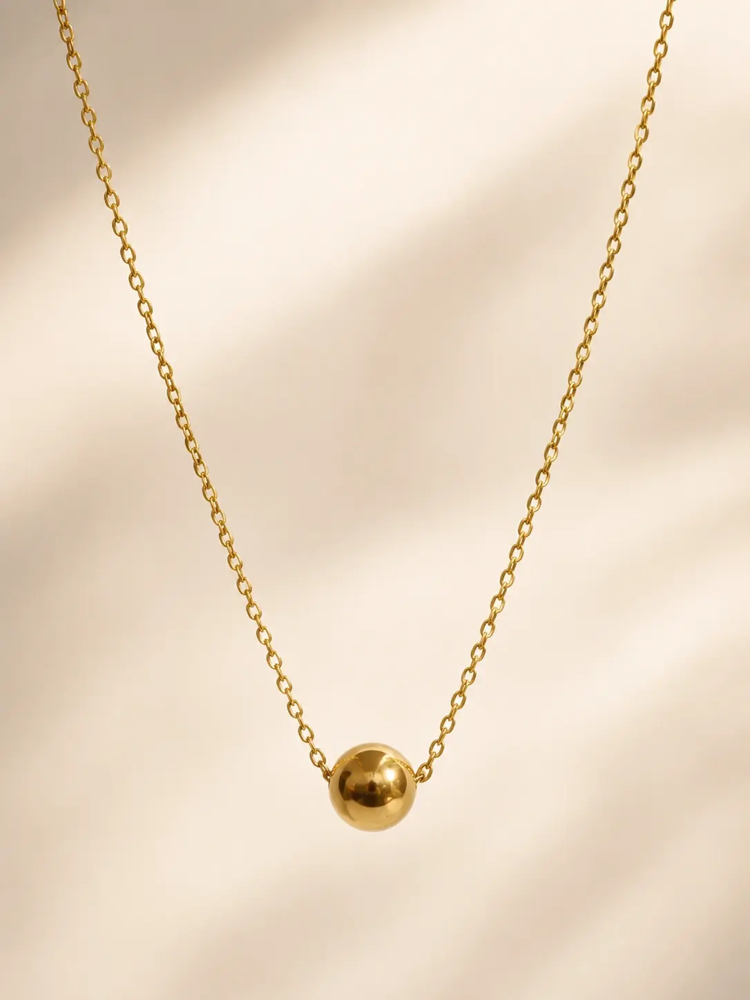 gold ball pendant necklace with polished spherical centerpiece