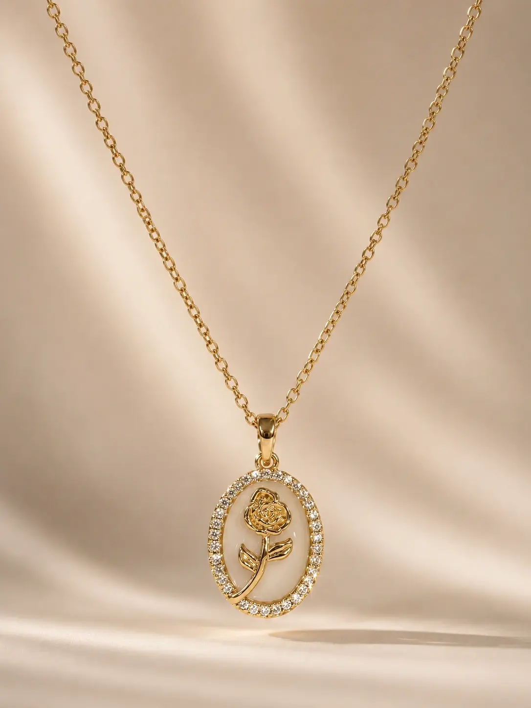 gold rose oval pendant necklace with clear accent border